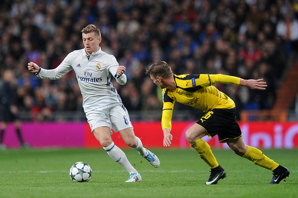 MADRID, SPAIN - DECEMBER 07: Toni Kroos of Real Madrid (L) takes the ball past Lukasz Piszczek of Borussia Dortmund (R) during the UEFA Champions League Group F match between Real Madrid CF and Borussia Dortmund at the Bernabeu on December 7, 2016 in Madrid, Spain.  (Photo by Denis Doyle/Getty Images)